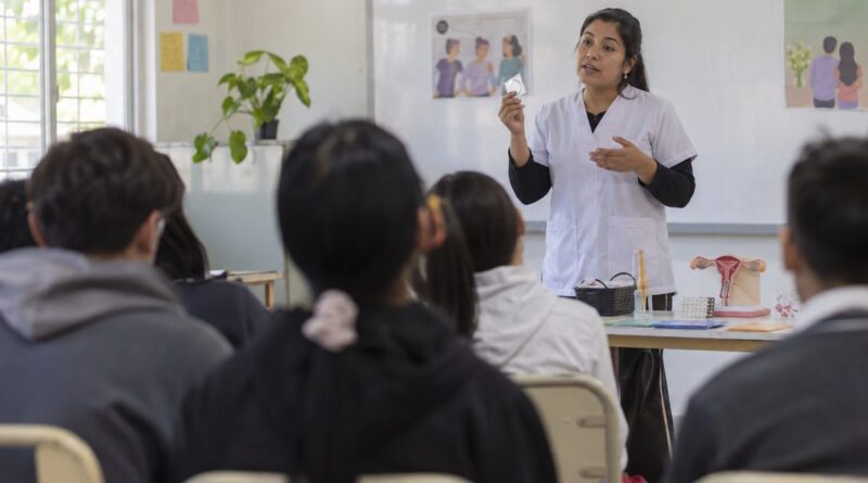 Profesional de salud brinda una charla ilustrativa a estudiantes dentro de un aula.