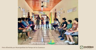 Encuentro grupal en un pasillo del CIC, con personas sentadas a ambos lados y una exposición al centro.