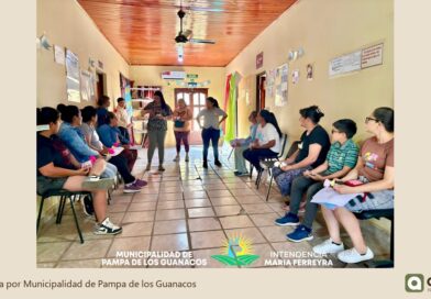 Encuentro grupal en un pasillo del CIC, con personas sentadas a ambos lados y una exposición al centro.