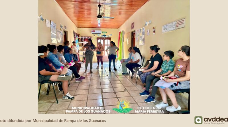 Encuentro grupal en un pasillo del CIC, con personas sentadas a ambos lados y una exposición al centro.
