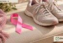 Cinta rosa junto a zapatillas sobre tela clara; imagen simbólica de concientización y actividad física.